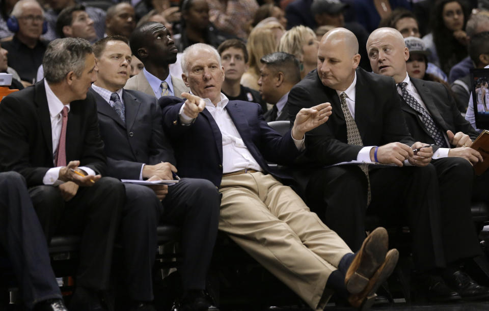 San Antonio Spurs coach Gregg Popovich, center, talks to his assistants during the second half of an NBA basketball game against the Los Angeles Lakers, Wednesday, April 16, 2014, in San Antonio. Los Angeles won 113-100. (AP Photo/Eric Gay)