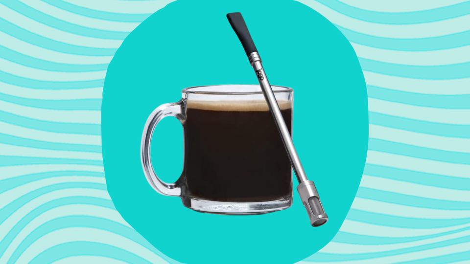 the coffee-brewing straw leaning against a coffee mug