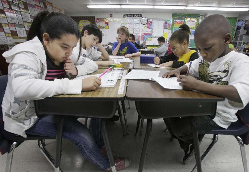 FILE - Third-grade students do school work during class at Hanby Elementary School, Feb. 15, 2011, in Mesquite, Texas. Friday, May 17, 2024, marks 70 years since the U.S. Supreme Court ruled that separating children in schools by race was unconstitutional. On paper, Brown v. Board of Education still stands. In reality, school integration is all but gone, the victim of a gradual series of court cases that slowly eroded it, leaving little behind. (AP Photo/LM Otero, File)
