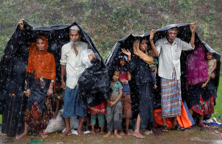 Rohingya refugees shelter from the rain in a camp in Cox's Bazar, Bangladesh, September 17, 2017. REUTERS/Cathal McNaughton