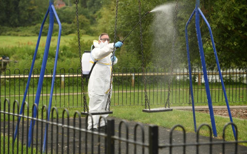 A stock controller works to sanitise the playground equipment in Churchill Garden's in Salisbury - Russell Sach