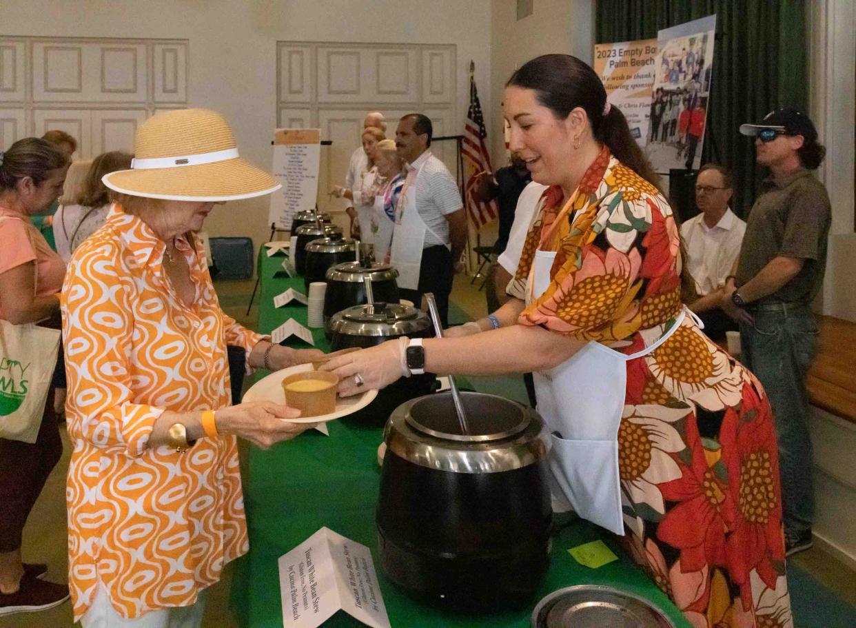 Stephanie Glavin, right, serves up a bowl of Tuscan white bean stew made by Cucina Palm Beach during the 10th Annual Empty Bowls event at the Episcopal Church of Bethesda-by-the-Sea in February 2023. This year's Empty Bowls is set for Feb. 23.