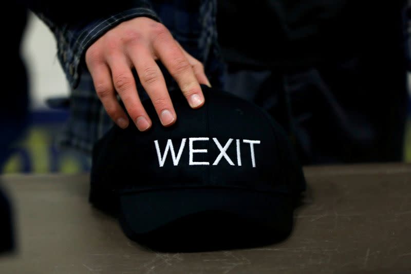 FILE PHOTO: A supporter holds his Wexit hat while attending a rally for Wexit Alberta, a separatist group seeking federal political party status, in Calgary