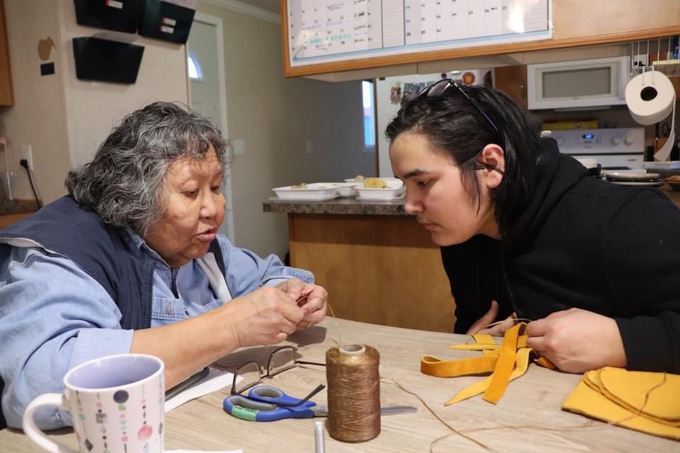 Resident elder Dorothy Bellrose with Shane Clenette, making regalia for Clenette as part of the Northern Cultural Expressions Society's regalia program in Whitehorse.