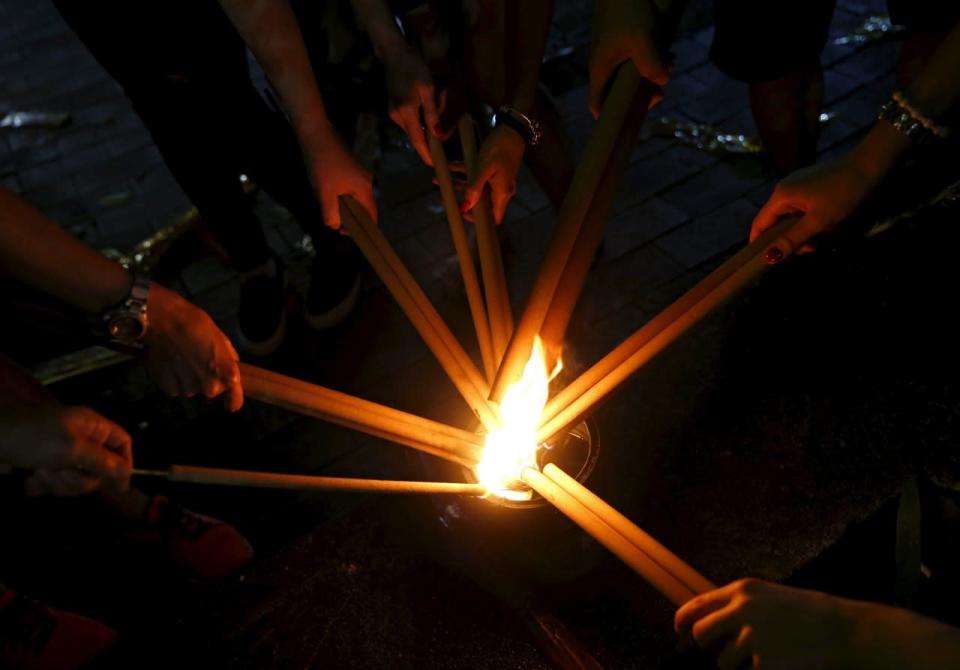 People light their joss sticks as they wait to plant their first joss sticks of the Lunar New Year of the Monkey at the stroke of midnight at the Kwan Im Thong Hood Cho temple on 7 February. Photo: Reuters/Edgar Su.