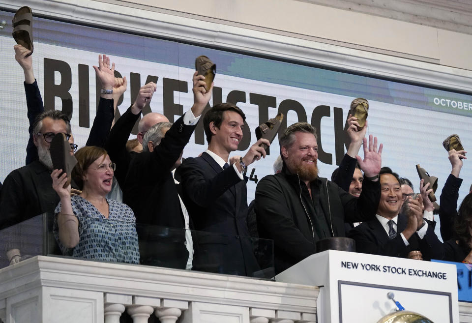 Birkenstock CEO Oliver Reichert, second from right, waves as he rings the New York Stock Exchange opening bell, prior to his company's IPO, Wednesday, Oct. 11, 2023. (AP Photo/Richard Drew)