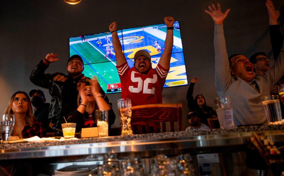 Alejandro Reyes (52) and other customers cheer in 2022 at Public House Downtown in Sacramento as the San Francisco 49ers play the Los Angeles Rams in the NFC Championship.