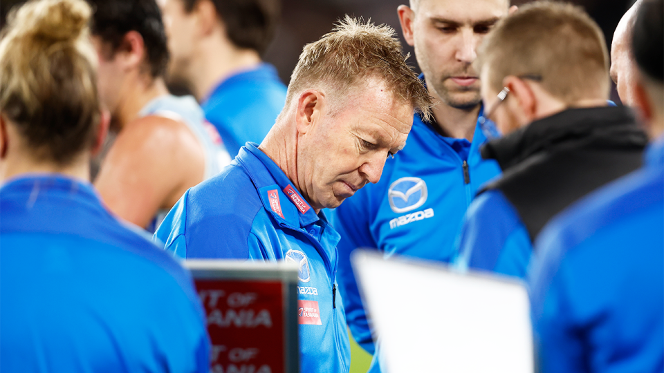 North Melbourne coach David Noble (pictured) speaks to his team during an AFL quarter-time break.