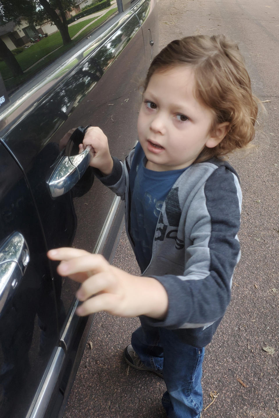 In this Thursday Aug. 22, 2019 photo provided by George Hendrickson, his son, Eliyah, waits to enter his father's truck for the first day of school in Harrisburg, S.D. The 7-year-old has been diagnosed with Dravet syndrome and his father would like to see the state approve medical marijuana to aid in his treatment. Volunteers are gathering signatures to get an initiated measure on the November ballot. (George Hendrickson via AP)