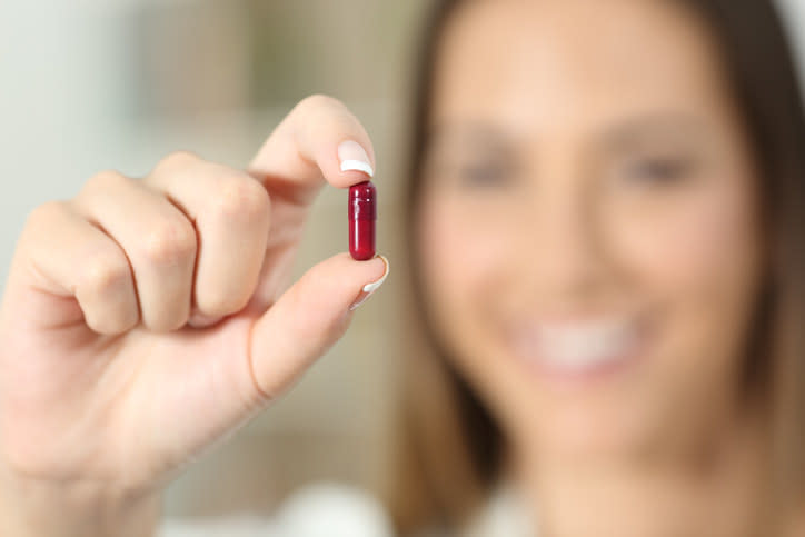 woman holding a pill