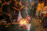 GAZA, PALESTINE - 2020/10/25: Protesters burning placards with portraits of the French president during the demonstration. Palestinians in the city of Rafah protest against the publishing of cartoons as Prophet Muhammad in a French newspaper and the statement of French President Emmanuel Macron. (Photo by Yousef Masoud/SOPA Images/LightRocket via Getty Images)