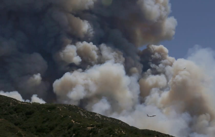 BEAUMONT, CA - AUG.1, 2020. A jumbo jet firefighting plane is dwarfed by the smoke plume of the Apple fire in the hills above Beaumont on Saturday, Aug. 1, 2020. The fire has charred more than 4,000 acres and destroyed at least one home. (Luis Sinco/Los Aneles Time)