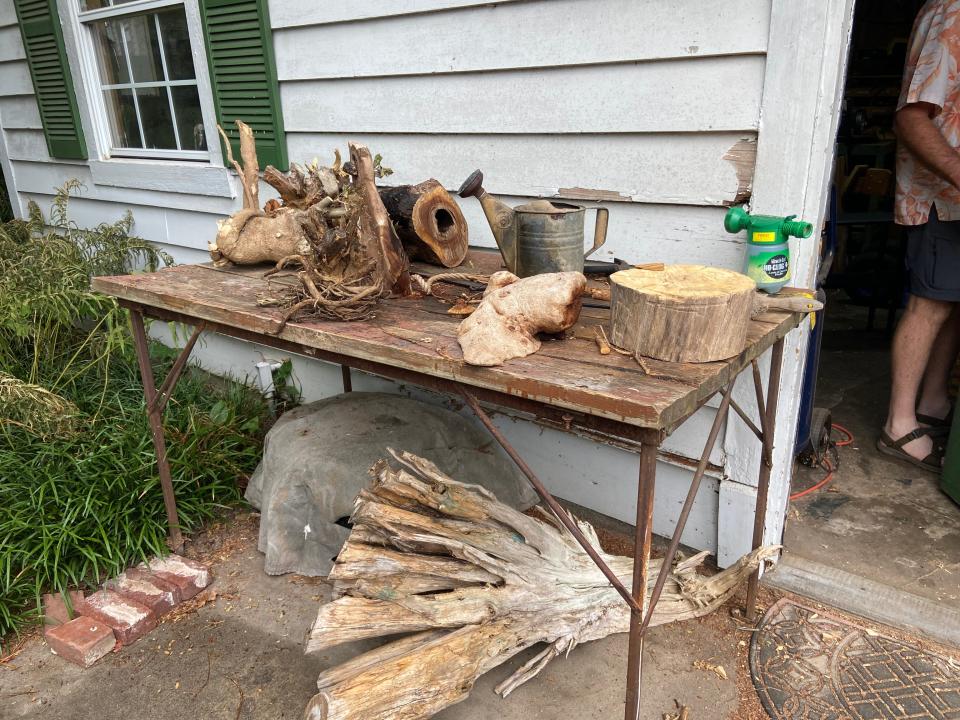 Pieces of wood sit outside Stephen Holmes' workshop awaiting to be carved into their finished shape.