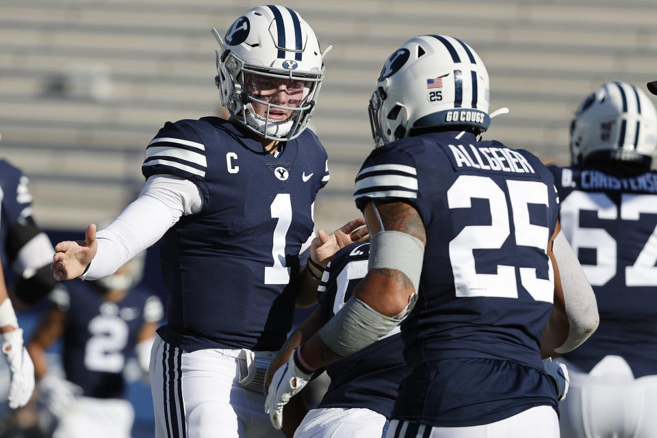 BYU quarterback Zach Wilson (1) congratulates running back Tyler Allgeier (25) after his first quarter touchdown against North Alabama during an NCAA college football game Saturday, Nov. 21, 2020, in Provo, Utah. (AP Photo/Jeff Swinger, Pool)