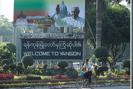 A man rides past a banner welcoming Pope Francis, ahead of his visit to Yangon, Myanmar November 26, 2017. REUTERS/Jorge Silva