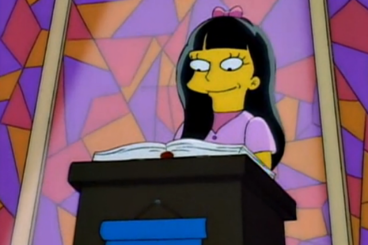 Jessica Lovejoy stands at the front of a church, reading from a large book, with light shining on her from above