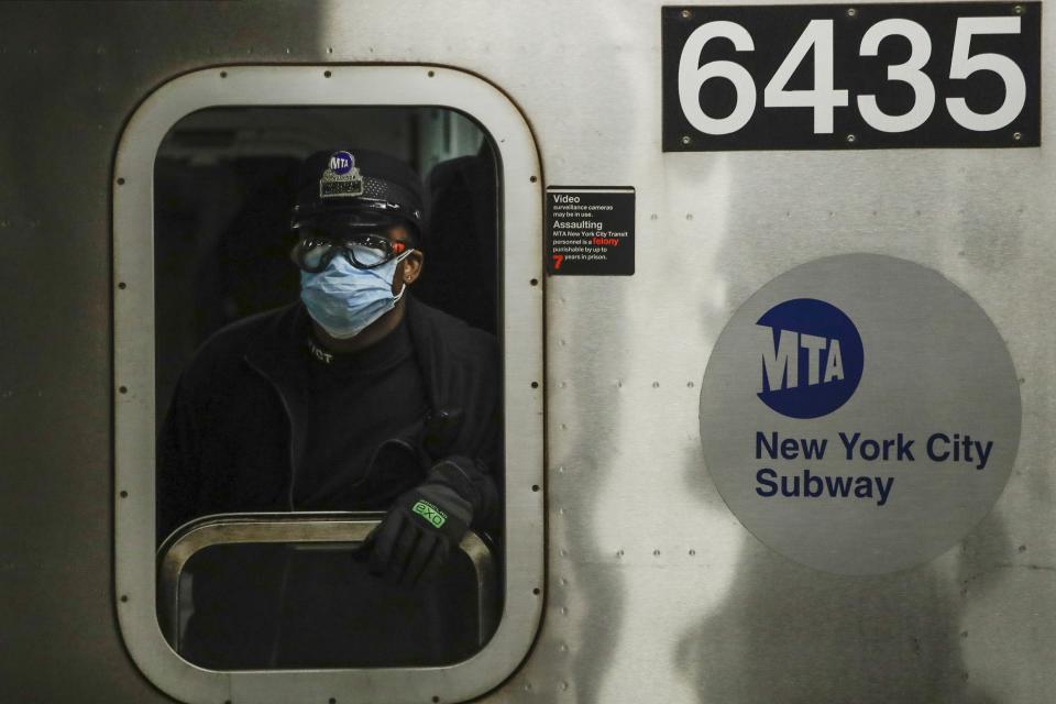 FILE - In this April 7, 2020, file photo, an MTA worker wears personal protective equipment at the Grand Army Plaza station in the Brooklyn borough of New York. As the coronavirus tightened its grip across the country, it is cutting a particularly devastating swath through an already vulnerable population, black Americans. (AP Photo/Frank Franklin II, File)