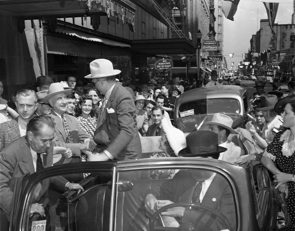 Sept. 20, 1940: Following a parade on 7th Street in downtown Fort Worth, movie studio mogul Samuel Goldwyn shakes hands with Amon Carter, owner of the Star-Telegram. In car is Mrs. Goldwyn and Gary Cooper, star of the movie “The Westerner,” partially filmed in and around Fort Worth. Fort Worth Star-Telegram archives/UT Arlington Special Collections