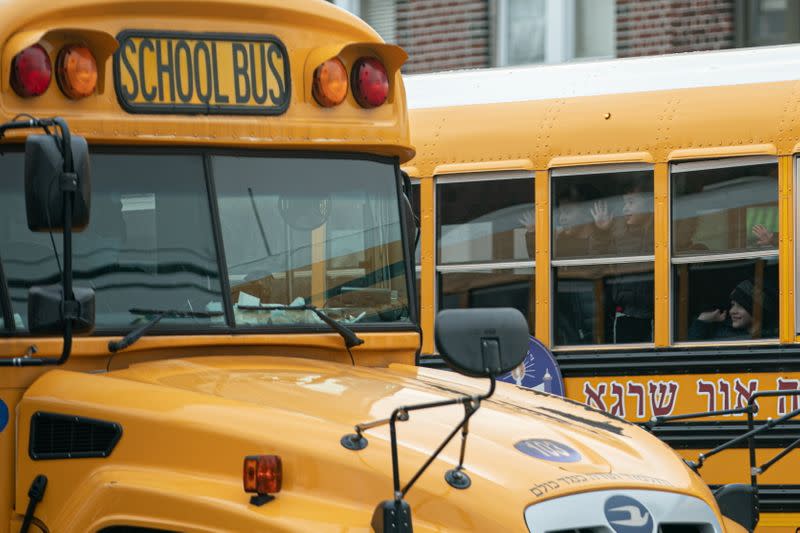 Children look out the window of a school bus during the COVID-19 pandemic in the Brooklyn borough of New York City