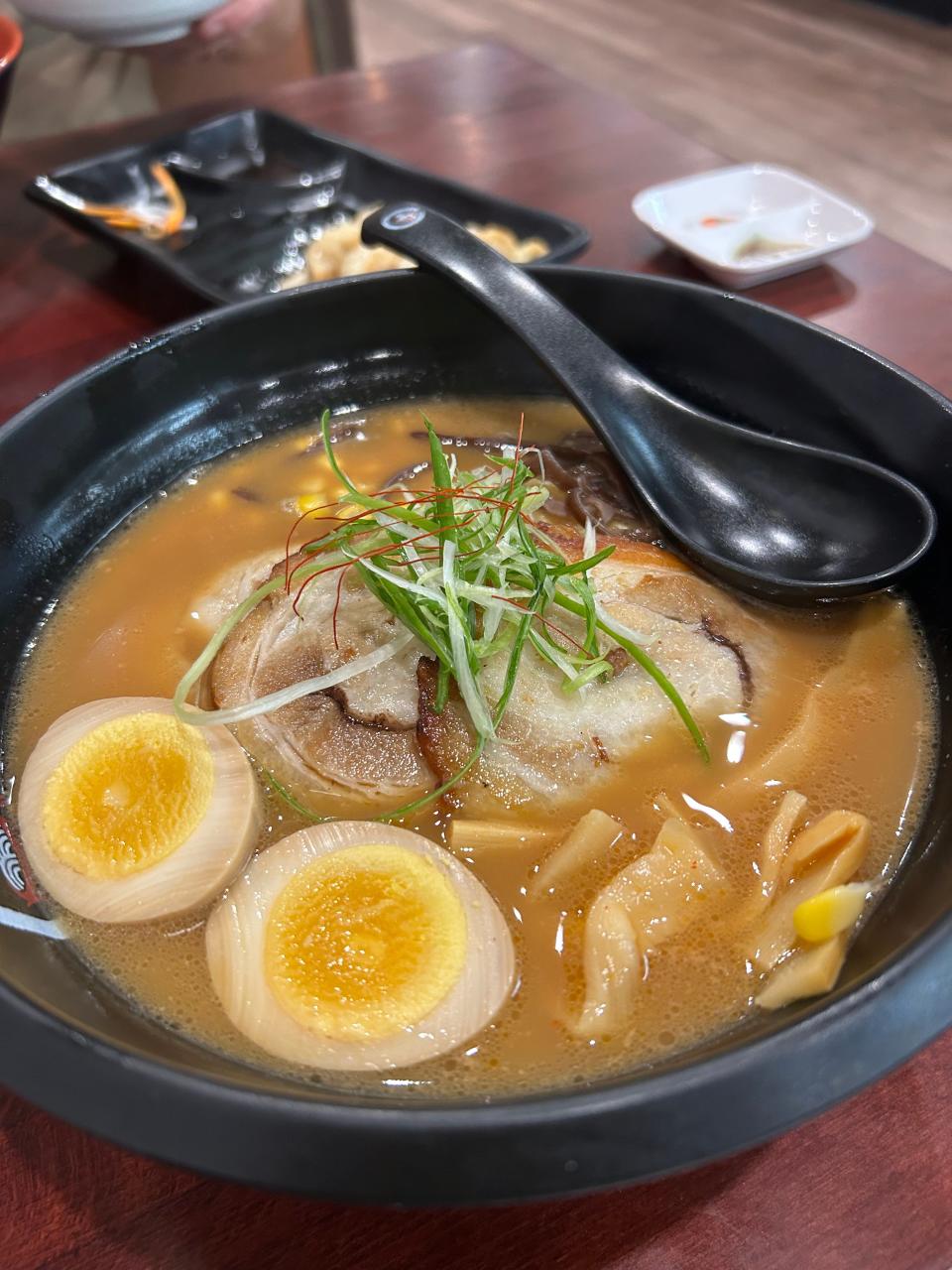 Tokyo ramen is made with ramen noodles, shoyu soup, chasu pork, marinated egg, bamboo shoots, corn, wakama and nori seawood and scallions in pork broth.