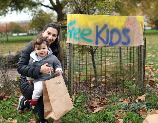 Lucy Turpin and her 11-month-old baby Sophie with a bag of food provided by volunteers in London Fields, east London