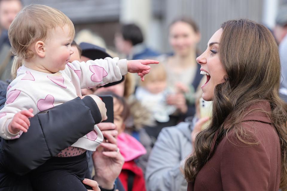 Catherine, Duchess of Cornwall with a toddler that playfully points at her after the tour of the National Maritime Museum Cornwall