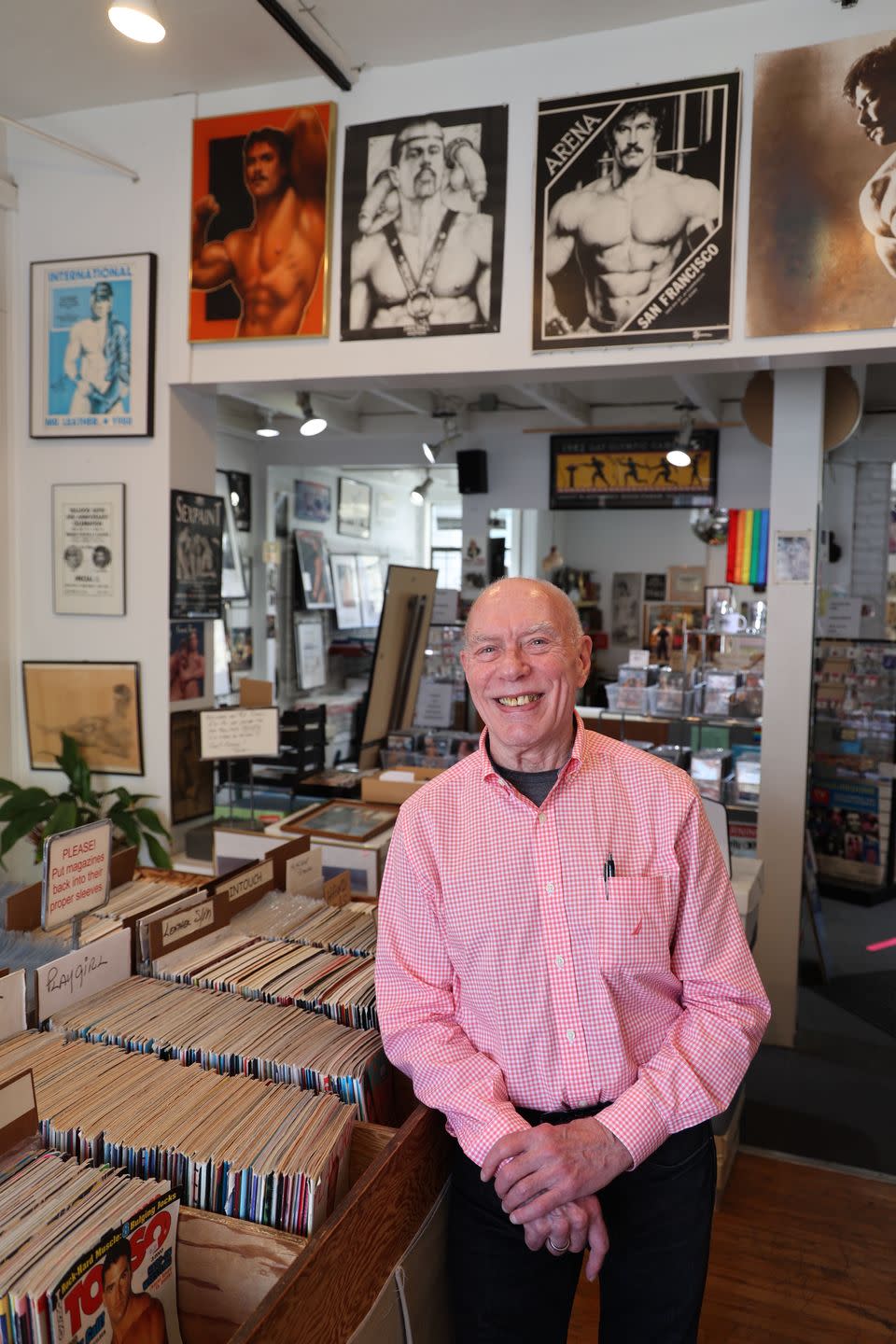 a man standing in a room with posters on the wall