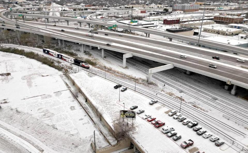 A thin layer of snow covers the ground as vehicles travel along I-30 in downtown Fort Worth on Monday, January 15, 2024.