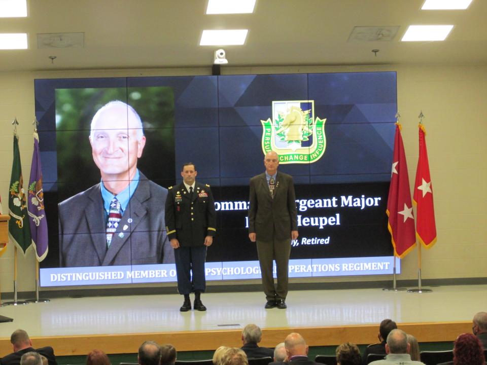 Retired Command Sgt. Maj. Neil Heupel is welcomed by Lt. Col. Jeffrey Souther as a distinguished member of the psychological operations regiment during a Nov. 4, 2021, ceremony at Fort Bragg.