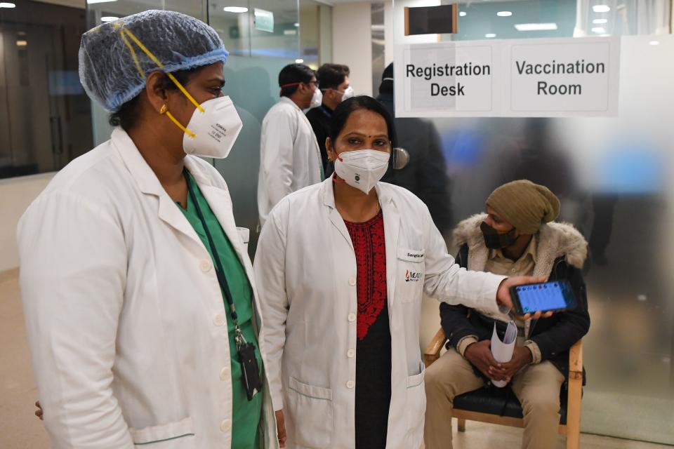 Security and healthcare workers wait for the start of the Covid-19 coronavirus vaccination drive at the Max hospital in New Delhi on January 16, 2021. (Photo by Prakash SINGH / AFP) (Photo by PRAKASH SINGH/AFP via Getty Images)