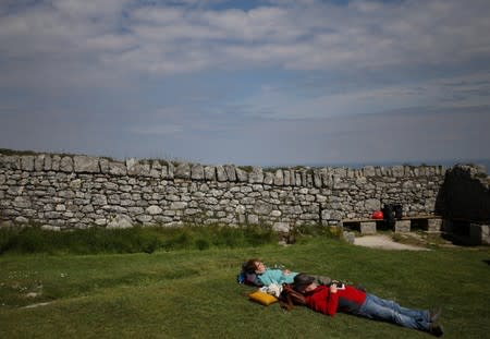 Members of the Cloud Appreciation Society take a break on the grass after arriving in Lundy