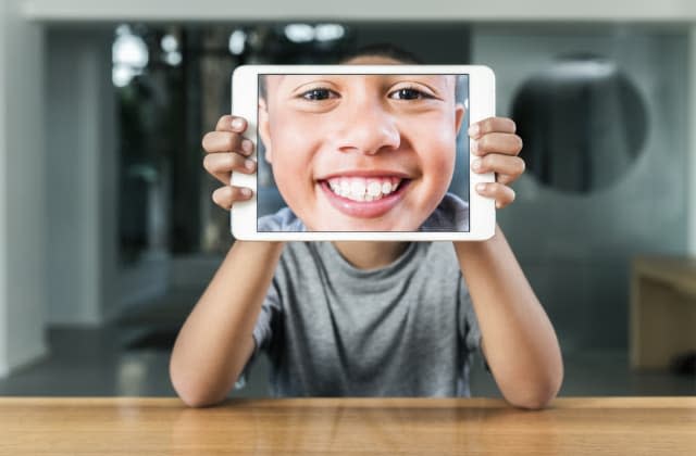 Happy boy taking self portrait