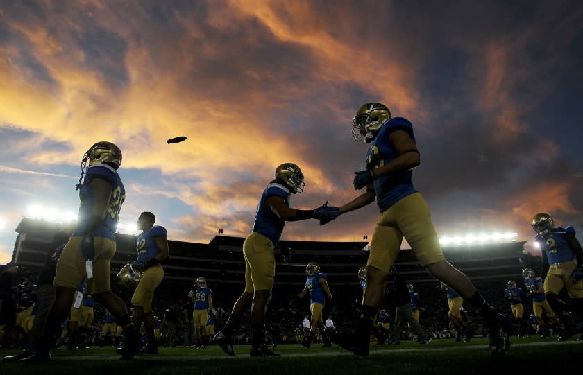 UCLA players warm up before the start of a game against crosstown rival USC on Saturday at the Rose Bowl.