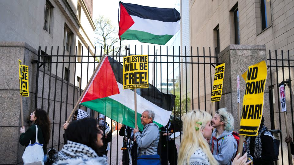 Pro-Palestinian supporters wave flags in front of the entrance of Columbia University in New York City on April 22. - Charly Triballeau/AFP/Getty Images