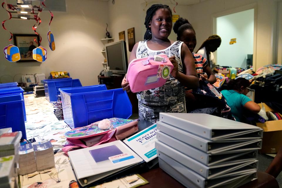 Aaliyah Floyd, 10, selects school supplies at the annual Back to School Distribution Day at The Pantry, Friday, July 29, 2022, in Fort Lauderdale, Fla. The Pantry works with grandparents who are the primary caregivers for their grandchildren, offering free backpacks, lunch boxes, school supplies and sneakers. This back-to-school shopping season, parents, particularly in the low to middle income bracket, are focusing on the basics, trading down to cheaper stores and stretching out their buying as surging inflation takes a toll on their household budgets. (AP Photo/Lynne Sladky)