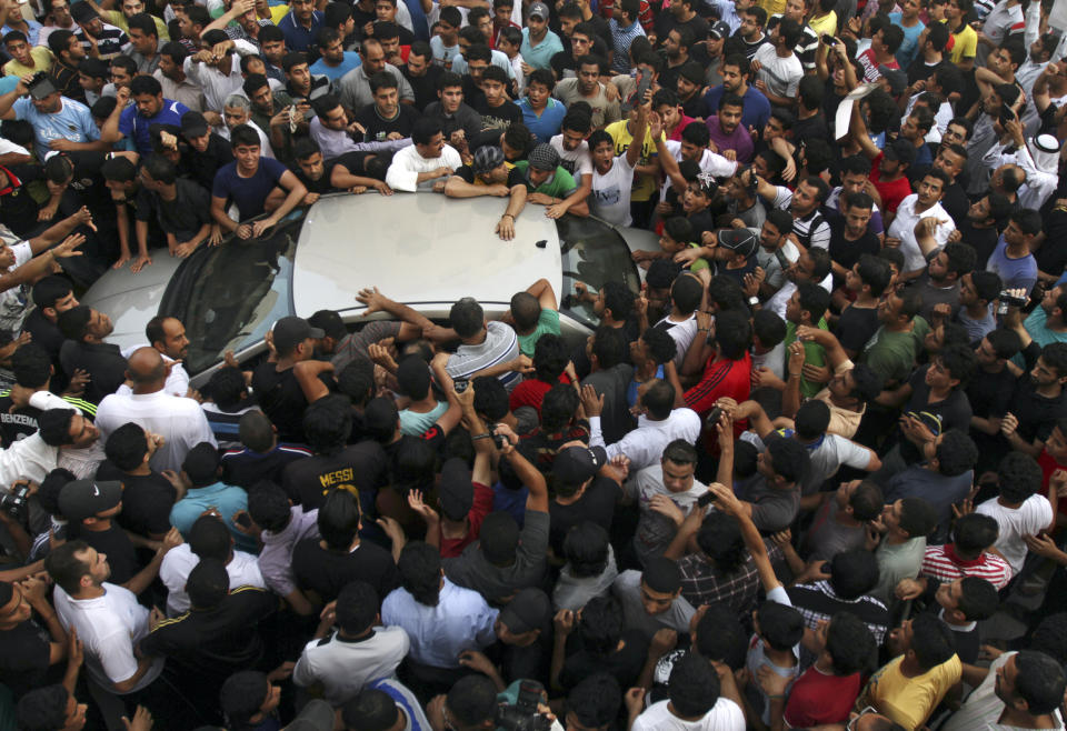 File - In this Monday, May 20, 2013 file photo, crowds rush to greet Bahraini Shiite opposition political leader Abdul Wahab Hussein, inside vehicle, as he arrives from prison to his home in Nuwaidrat, Bahrain. A decade ago, against all odds, a popular uprising convulsed the monarchy of Bahrain as a wave of revolutionary protests swept across the Middle East. But after a brutal crackdown and years of escalating repression, activists say the small kingdom is less free now than even before the Arab Spring, as authorities crush hopes for political reform. (AP Photo/Hasan Jamali, File)