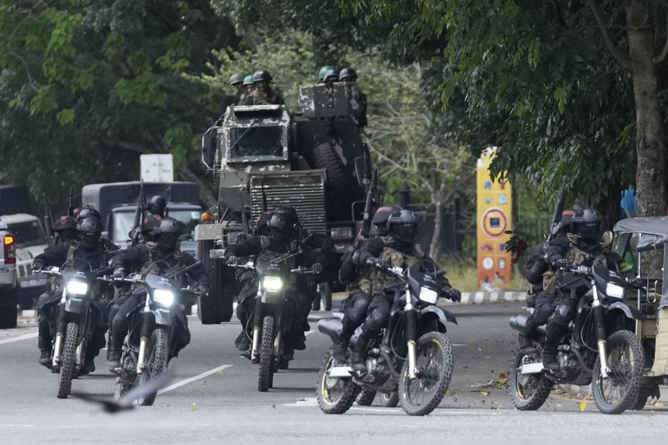 Special force soldiers patrol a road that leads to the parliament in Colombo, Sri Lanka, Thursday, July 14, 2022. Sri Lankan protesters began to retreat from government buildings they had seized and military troops reinforced security at the Parliament on Thursday, establishing a tenuous calm in a country in both economic meltdown and political limbo. (AP Photo/Eranga Jayawardena)