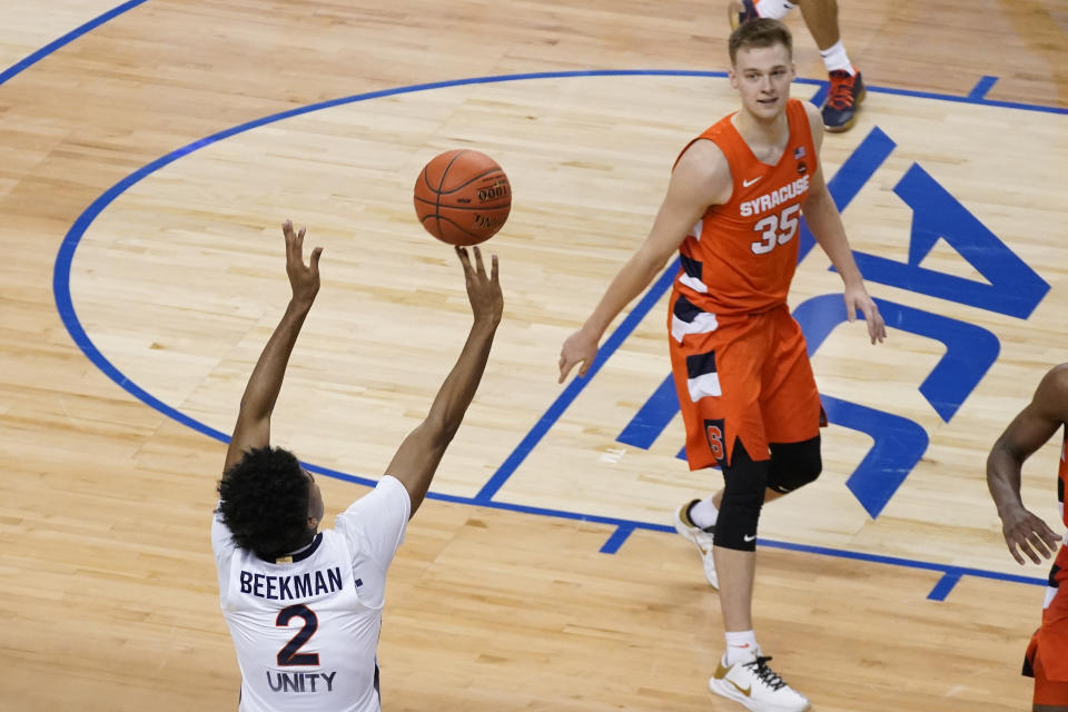 Virginia guard Reece Beekman (2) launches the game winning shot as Syracuse guard Buddy Boeheim (35) watches during the second half of an NCAA college basketball game in the quarterfinal round of the Atlantic Coast Conference tournament in Greensboro, N.C., Thursday, March 11, 2021. Virginia won the game 72-69. (AP Photo/Gerry Broome)