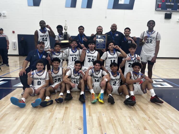 The Garfield boys' basketball team celebrates its City Section Division III title.