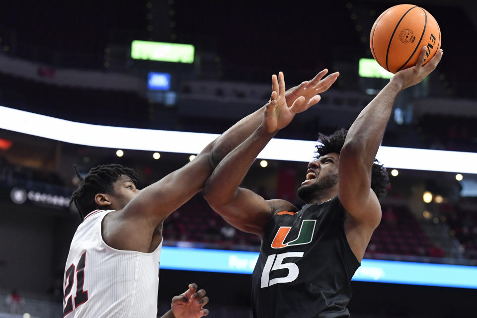 Miami forward Norchad Omier (15) shoots over Louisville forward Sydney Curry (21) during the first half of an NCAA college basketball game in Louisville, Ky., Sunday, Dec. 4, 2022. (AP Photo/Timothy D. Easley)