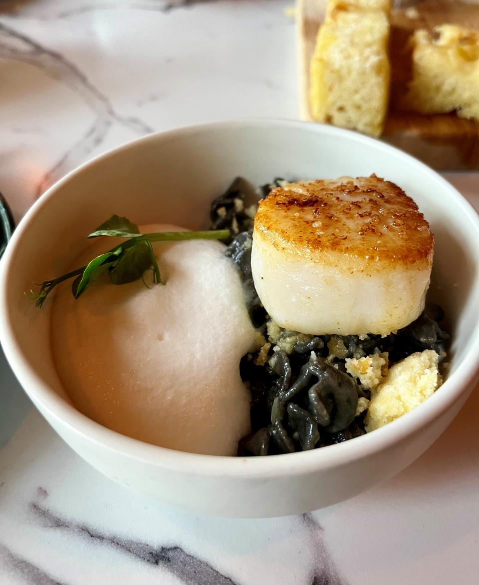 Scallops are seared to a juicy char and paired with squid-ink fusilli at Next Door in Tarpon Point Marina.