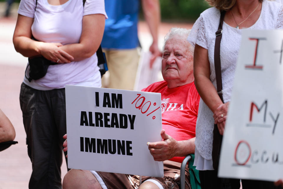 A protester holds a placard that says I am already immune during the demonstration in Bloomington, Indiana on June 10, 2021.
(Jeremy Hogan/SOPA Images/LightRocket via Getty Images)