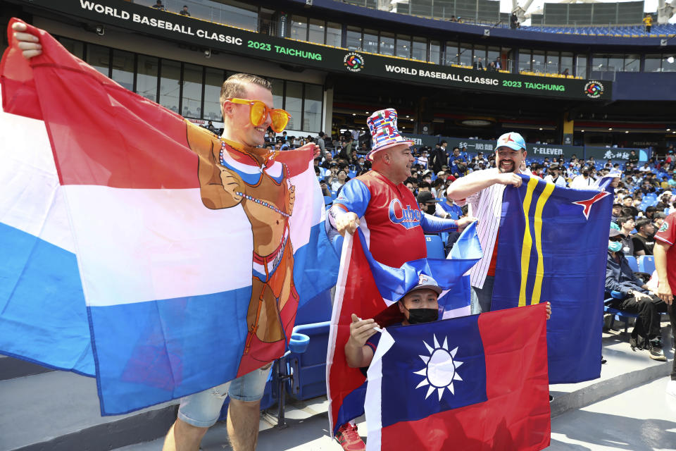 Baseball fans hold nationals flags of Cuba, Taiwan and Netherlands in the World Baseball Classic (WBC) held at Taichung Intercontinental Baseball Stadium in Taichung, Taiwan on Wednesday, March 8, 2023. (AP Photo/I-Hwa Cheng)