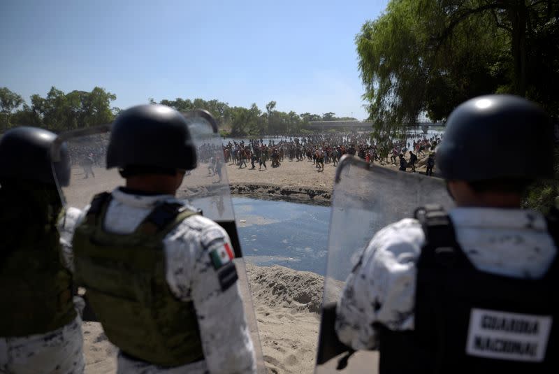 Members of Mexico's National Guard hold their shields to block migrants, part of a caravan travelling to the U.S., near the border between Guatemala and Mexico, in Ciudad Hidalgo