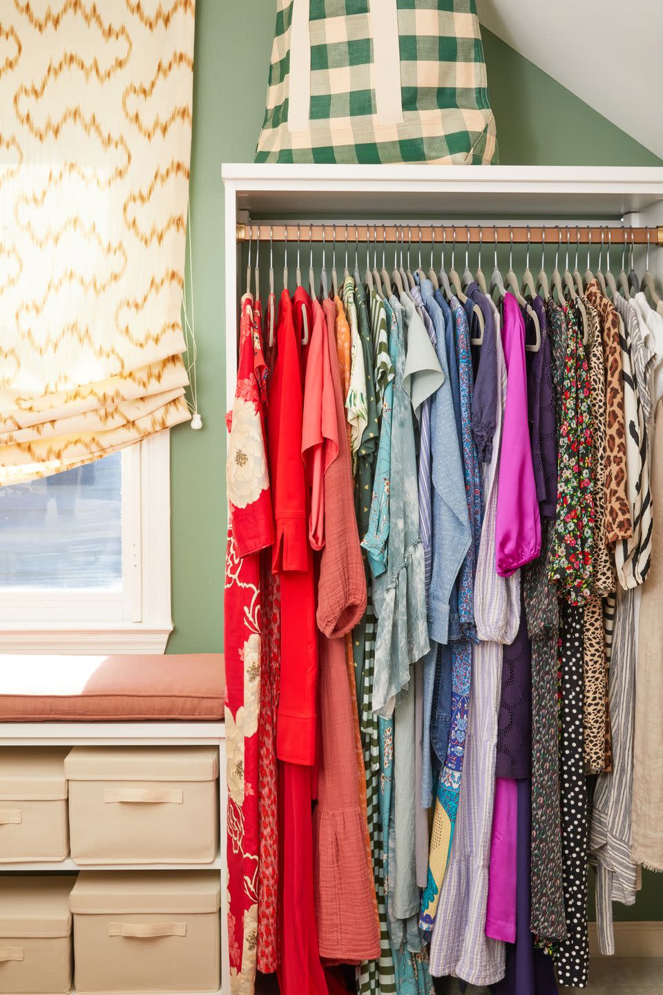 a closet full of clothes hanging in rainbow order