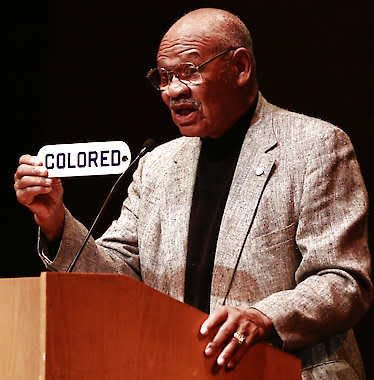 In 2012, former Indiana University and NFL football player George Taliaferro holds the “COLORED” sign he took from the Princess Theater during the 1940s, when all the Bloomington theaters were segregated.