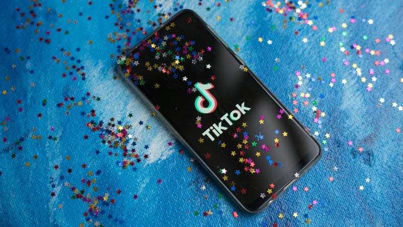 The TikTok app displayed on a phone covered in glitter.