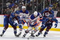 Edmonton Oilers right wing Connor Brown, front center, and Colorado Avalanche center Casey Mittelstadt, left, and defenseman Devon Toews vie for the puck during the second period of an NHL hockey game Thursday, April 18, 2024, in Denver. Edmonton center Sam Carrick, back left, and Colorado right wing Valeri Nichushkin trail the play. (AP Photo/David Zalubowski)