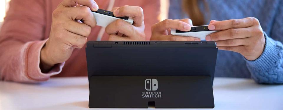 inbody people playing nintendo switch oled model 2021 on table joycons