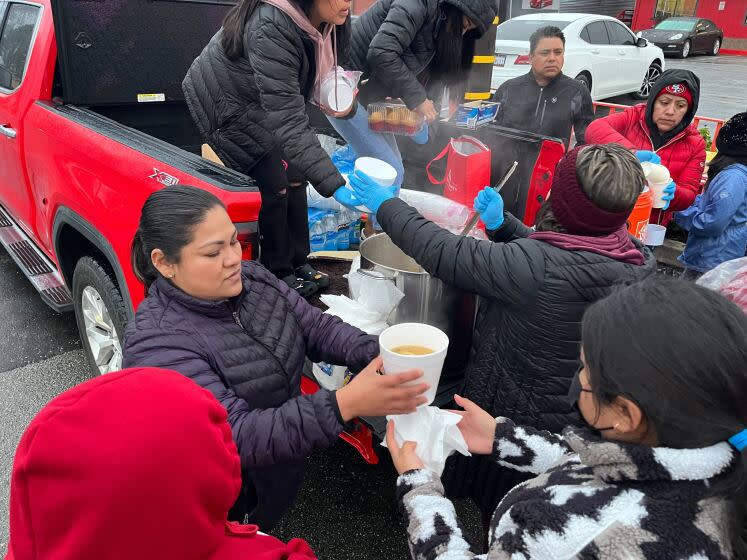 Sara Perez, 36 helps distribute foam containers of chicken soup to people displaced by floods in Pajaro.